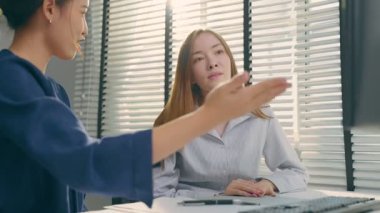 İki kadın parlak bir odada bir şey tartışıyor..