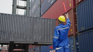 Kargo limanında çalışan koruyucu kasklı erkek mühendis, ihracat için kargo konteynerleri.