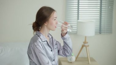 İçerideki camdan su içen genç kadın..