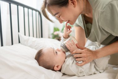 Asyalı genç bir anne bebeğini evde büyütür ve büyütür. Çekici bir anne bebeğini süt şişesinden besliyor, çocuğunu sıcak aile ortamında beslerken hassas bir anı paylaşıyor.
