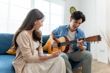 Asyalı genç çift boş zamanlarını birlikte oturma odasında geçiriyorlar. Çekici yeni evli erkek ve kadın kanepede oturur ve sabahları gitar çalıp şarkı söylerler. Evde etkinlik ilişkisi
