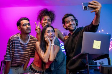 Çeşitli erkek ve kadın grupları parti yaparken fotoğraf çekiyorlar. Çekici genç arkadaşlar DJ ile eğleniyor. Müzik mikseri düzenleyicisi ve neon lambalı ev partisinde karıştırıcı..