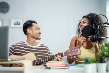 Çeşitli arkadaşlar gitar çalıyor ve evde elektronik film müzikleri yapıyor. Müzik stüdyosunda müzik aleti ve ses ekipmanı kullanarak yeni bir şarkı besteleyen çekici erkek ve kadın müzisyen.