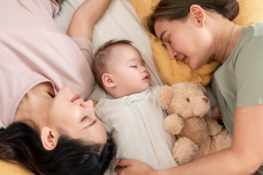 Asyalı lezbiyen çift, erkek çocuklarını evde büyütür ve onlarla ilgilenir. İki çekici kadın anne, yeni doğmuş bebeklerinin yanında uyudukları sıcak aile ortamında şefkatli bir anı paylaşıyorlar.