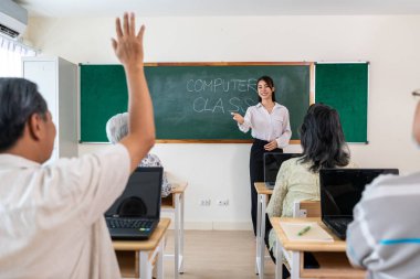 Asyalı bayan eğitmen, okulda olgun öğrencilere ders veriyor. Çekici öğretmen son sınıf öğrencisine özel ders sırasında dizüstü bilgisayar kullanmayı öğretir..