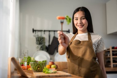 Evdeki mutfakta Vietnam böreği yiyen kadın portresi. Önlük giyen çekici, güzel bir kız. Sabahları evdeki sağlık için temiz aperatifler yiyor. Diyet ve Sağlıklı Yemek Konsepti