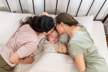 Asyalı lezbiyen çift, erkek çocuklarını evde büyütür ve onlarla ilgilenir. İki çekici kadın anne, uyuyan çocuklarını sıcak aile ortamında büyütürken hassas anlarını paylaşıyorlar..