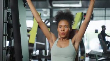 Afrikalı Amerikalı sporcu kadın spor salonunda ağırlık makinesi ya da halter kaldırıyor. Çekici genç sporcu bayan spor salonu sağlık hizmetleri için ağırlık ekipmanı kullanın ve fitness kulübündeki kaslarınızı koruyun.