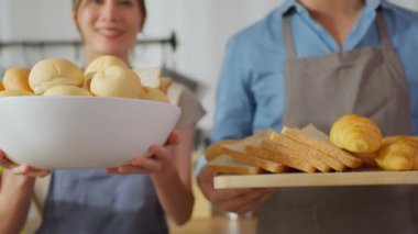 İki kişi ekmek ve ekmek tutuyordu.