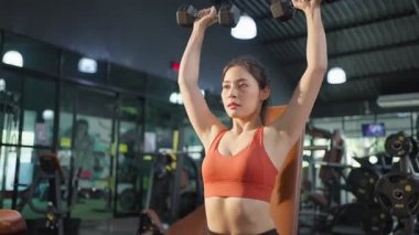 Spor salonunda kas geliştirmek için egzersiz yapan Asyalı genç bayan. Spor kıyafetleriyle spor salonunda spor salonunda spor salonunda spor salonunda spor salonunda spor salonunda spor salonunda halterleri ve sağlık hizmetleri için ağırlık kaldıran aktif ve güzel bir atlet..