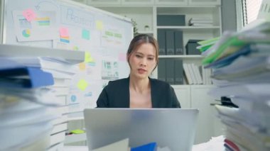 Ofis ortamında masa başında çalışan genç bir kadın..