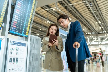 Havaalanı terminalinin dışında duran Asyalı iş kadını yolcu. Çekici, güzel bayan turist yurtdışında çalışmaktan mutlu ve heyecanlı hissediyor ve tatil gezisi için uçakla seyahat ediyor..