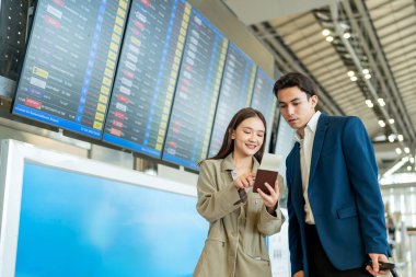 Havaalanı terminalinin dışında duran Asyalı iş kadını yolcu. Çekici, güzel bayan turist yurtdışında çalışmaktan mutlu ve heyecanlı hissediyor ve tatil gezisi için uçakla seyahat ediyor..