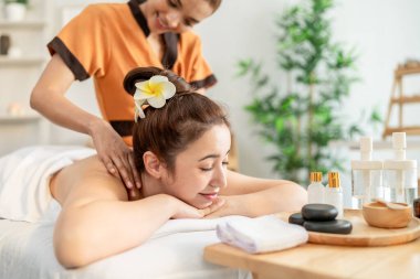 Güzel, rahatlatıcı bir kadın sıcak taşla sırt masajı yaptırıyor. Çekici genç kız masaj yatağında uzanıyor, kaplıca güzellik kliniğinde cilt ve vücut bakımı için masözden fizyoterapi alıyor..