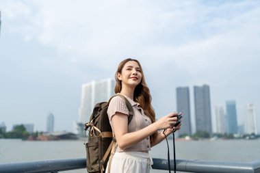 Asyalı genç ve güzel bir kadın sırt çantasıyla şehri keşfediyor. Çekici bayan gezgin kendini mutlu ve rahat hisseder, cadde boyunca yürümekten zevk alır ve tatil gezisinde boş zaman geçirir..