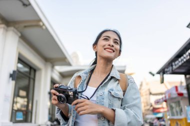 Asyalı genç ve güzel bir kadın sırt çantasıyla şehri keşfediyor. Çekici bayan gezgin kendini mutlu ve rahat hisseder, cadde boyunca yürümekten zevk alır ve tatil gezisinde boş zaman geçirir..