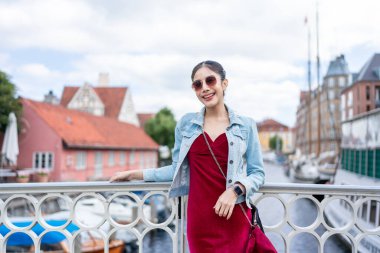 Şehirde gezen Asyalı genç bir sırt çantasının portresi. Çekici bayan turist, Danimarka 'da tatil gezisi sırasında sokakta yürür ve gülümser ve kameraya bakar..