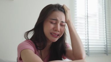 Pencerenin yanında oturan bir kadın ağlıyor