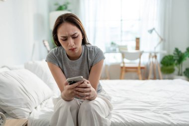 Asyalı bunalımlı genç bir kadın yatak odasında cep telefonuna bakıyor. Çekici, hayal kırıklığına uğramış kız kendini kayıp, yalnız ve hayat sıkıntısı içinde hisseder. Yatakta oturup akıllı telefonları izlerken.