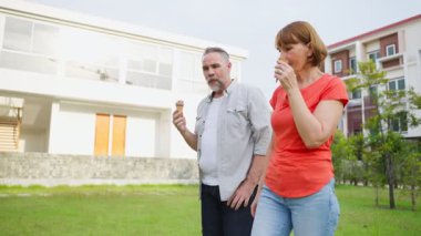 Modern evin önünde dondurma yiyen bir çift.