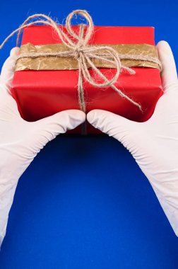 Kız lastik eldivenlerde bir hediye kutusu tutuyor. Yüksek kalite fotoğraf