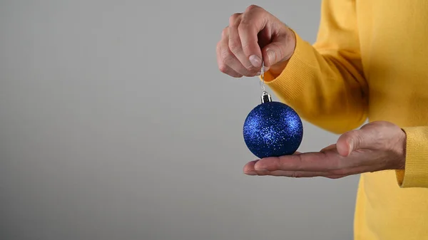 Ένας Άντρας Που Κρατάει Μια Μπλε Χριστουγεννιάτικη Μπάλα Στο Χέρι — Φωτογραφία Αρχείου