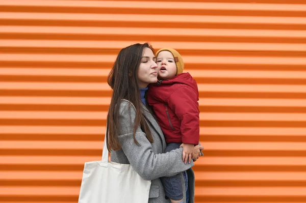 Mutter mit Baby auf orangefarbenem Hintergrund — Stockfoto