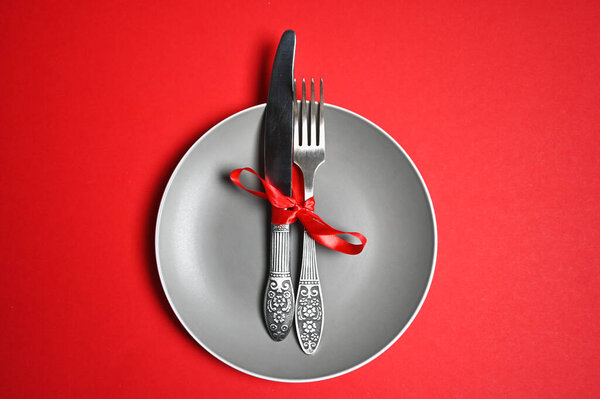Рождественский стол с тарелкой, вилкой, ножом. вид сверху, место для копирования. на красном фоне
