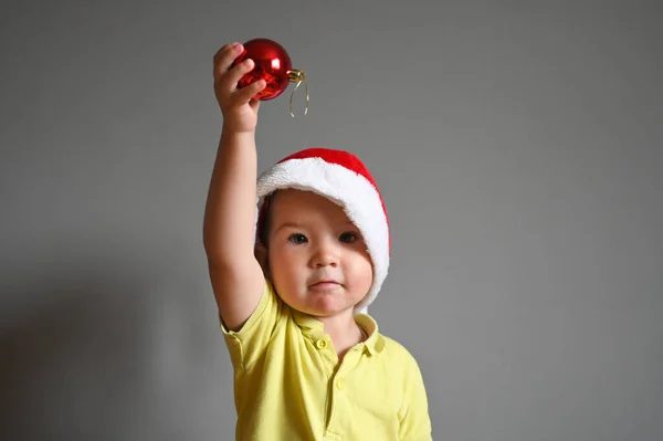 Dziecko Trzymające Piłkę Świątecznym Kapeluszu Wysokiej Jakości Zdjęcie — Zdjęcie stockowe