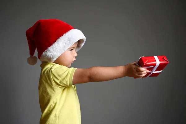Przystojny Chłopczyk Kapeluszem Mikołaja Głowie Trzymający Pudełko Prezentami Boże Narodzenie — Zdjęcie stockowe