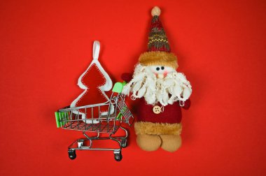 Alışveriş arabası kırmızı arka planda fotokopi alanı ile yatıyordu. İnternetten noel alışverişi konsepti. Mutlu yıllar, Xmas. - Evet. Yüksek kalite fotoğraf