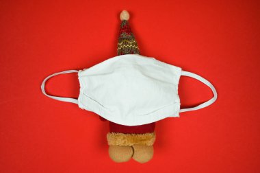 Koruyucu maskeli Noel Baba oyuncağı. Karantina sırasında Noel ve yeni yıl tatili. Yaklaş, üstten bak. - Evet. Yüksek kalite fotoğraf