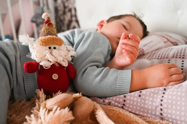 甜甜的高加索蟾蜍男孩睡在他的床旁边的玩具侏儒 圣诞节早上的概念 是的高质量的照片 — 图库照片