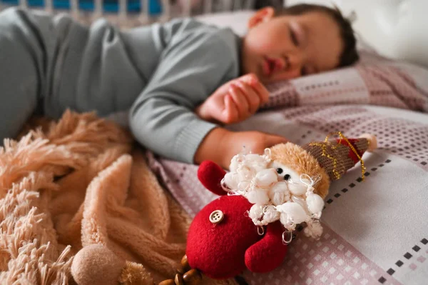 一个睡着了的小男孩的背景下的圣诞玩具 假日奇迹的概念 高质量的照片 — 图库照片