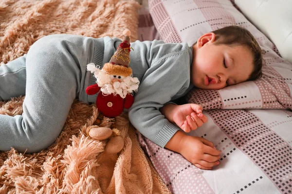 一个睡着了的小男孩的背景下的圣诞玩具 假日奇迹的概念 高质量的照片 — 图库照片