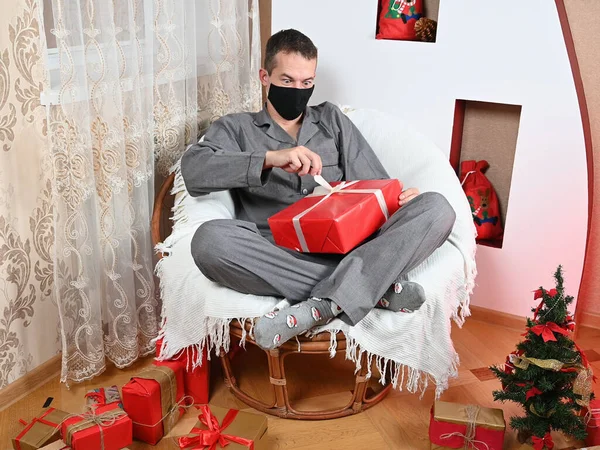 Een Man Pakt Een Geschenk Uit Een Masker Hoge Kwaliteit — Stockfoto