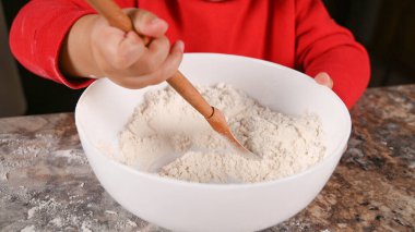 Çocuk kaşıkla un yoğurur. Yüksek kalite fotoğraf