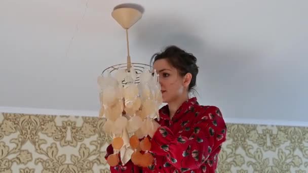 La jeune fille frotte le lustre de la poussière. Nettoyage de maison — Video