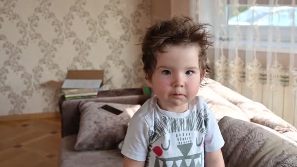 Cheerful curly boy looking at the camera. Positive baby — Stock Video