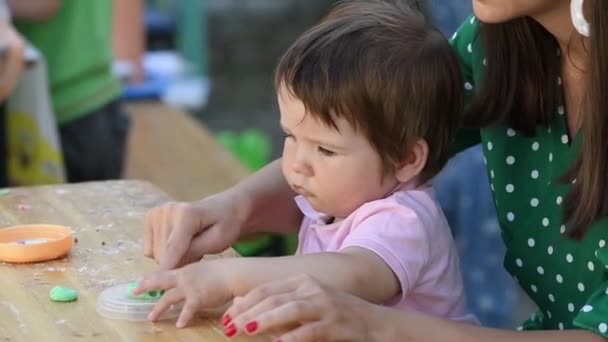 Junge Mutter spielt mit ihrem Sohn am Tisch in Knetmasse — Stockvideo