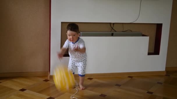 Das Kind spielt zu Hause mit einem Luftballon. Kinderspiele — Stockvideo