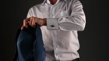 Beyaz gömlekli bir adam ceket giyer. koyu bir arkaplanda