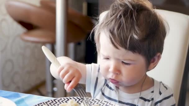 The child at the table eating hot food. Not cooled Breakfast child — Wideo stockowe