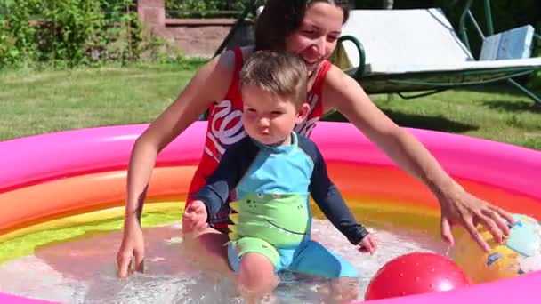 Madre e hijo escapan del calor en la piscina — Vídeos de Stock