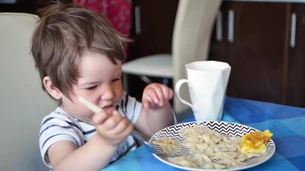 A criança à mesa a comer comida quente. Não arrefecido Pequeno-almoço criança — Vídeo de Stock