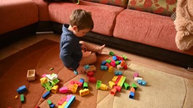 Çocuk otururken hevesle oynar. Yüksek kaliteli video