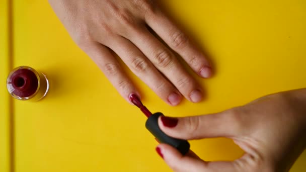 La chica se pinta las uñas con barniz rojo. Video de alta calidad — Vídeos de Stock