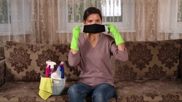 Meisje met een masker trekt rubberen handschoenen aan om de kamer schoon te maken — Stockvideo