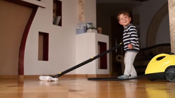 Il bambino lava il pavimento con un pulitore a vapore. Video di alta qualità — Video Stock