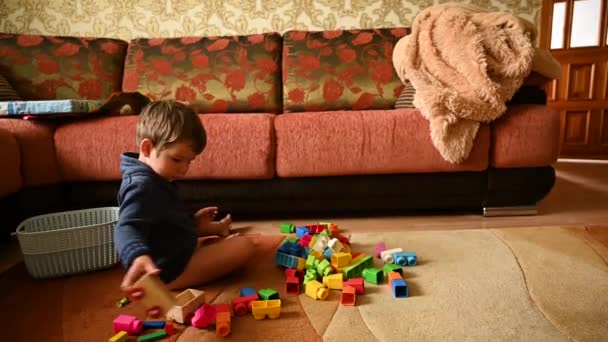 Kind spelen met speelgoed terwijl zitten op het tapijt — Stockvideo